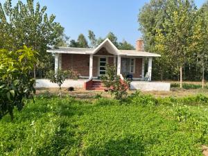 a brick house with a chimney on top of a yard at RajKamal's Farm in Borās