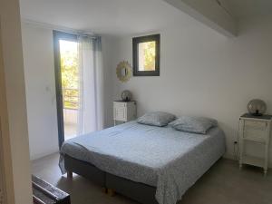 a white bedroom with a bed and a window at LES VILLAS LECCI E MARE in Zonza +60 photos