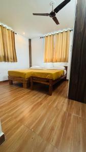 a bedroom with a bed and a ceiling fan at Hotel Royal Nest Inn in Coimbatore +2 photos