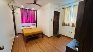 a small room with a bed and a window at Hotel Royal Nest Inn in Coimbatore