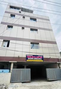 a tall building with a sign in front of it at Hotel Royal Nest Inn in Coimbatore