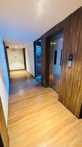 an empty room with a wooden floor and doors at Hotel Royal Nest Inn in Coimbatore