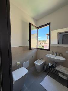 a bathroom with a toilet and a sink and a window at Elyas Guest House in Villasimius +42 photos