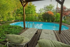 a swimming pool with a table and pillows in front of it at Panzió-Kemping Bekölce in Bekölce