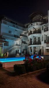 a large building with a swimming pool in front of it at Family Hotel Ludo in Varna City