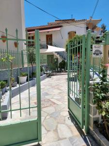 a green gate in front of a house at Aeolus Apartment I in Galaxidi