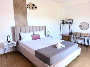 a bedroom with a large bed with two tables and a chair at Parea House in Limenaria