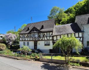 a white and black house with a black roof at Ferienappartement Tal der Liebe in Sauerthal