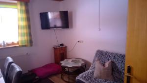 a living room with a couch and a tv on the wall at Fewo-Mirnig in Hochrindl