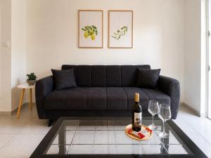 a living room with a couch and a bottle of wine at Linda's Apartment in Ialysos