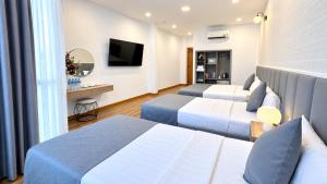 a hotel room with two beds and a television at Beauty House in Ho Chi Minh City