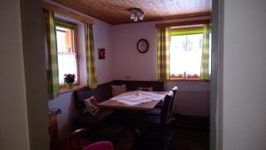 a dining room with a table and two windows at Fewo-Mirnig in Hochrindl