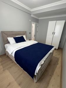 a bedroom with a large bed with a blue blanket at Bediroğlu Airport Apart in Arnavutköy