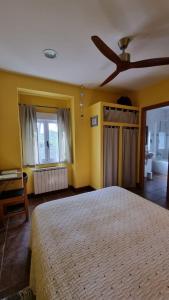 a bedroom with a bed and a ceiling fan at El Condado Casa Rural in Fuentes de Oñoro