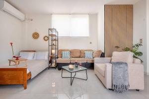 a living room with a couch and a table at S&M Cozy Garden Lagonissi in Lagonissi +34 photos