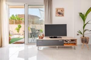 a living room with a flat screen tv on a table at S&M Cozy Garden Lagonissi in Lagonissi