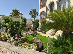 a garden with a statue of a lizard in a yard at Chalet Los Almendros con piscina privada in Calpe