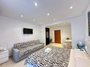 a living room with a zebra print bed and a couch at Consell Habitaciones in Barcelona