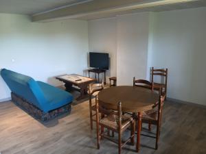 a living room with a table and chairs and a tv at Gite Atchoum in Hostun