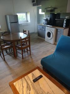 a living room with a table and a blue couch at Gite Atchoum in Hostun
