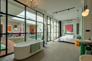 a bedroom with a bed and a tub in it at Hotel Eden Ubud in Ubud +60 photos