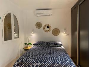 a bedroom with a bed with a blue and white comforter at Bella Javea in Jávea