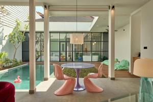 a living room with a table and chairs and a pool at Hotel Eden Ubud in Ubud