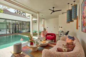 a living room with a swimming pool and a house at Hotel Eden Ubud in Ubud