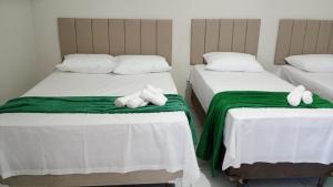 two beds with stuffed animals on them in a bedroom at Hotel Paulista Sobradinho BA in Sobradinho - Bahia
