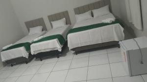two twin beds in a room withacers at Hotel Paulista Sobradinho BA in Sobradinho - Bahia