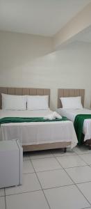 two beds sitting next to each other in a room at Hotel Paulista Sobradinho BA in Sobradinho - Bahia
