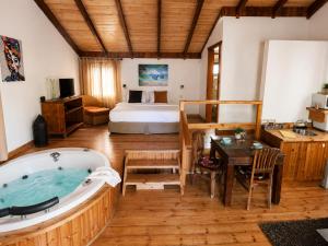 a room with a bath tub and a bedroom at אתנחתא בירדן in Mishmār Hāyardin