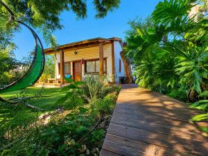 a house with a wooden walkway in front of it at אתנחתא בירדן in Mishmār Hāyardin