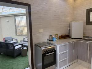 a kitchen with a stove and a refrigerator at راحتي in Al Baha