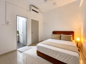 a white bedroom with a large bed and a bathroom at Seabreeze Hideout at Pantai Klebang Netflix I Wifi I Massage Chair I 7 pax in Malacca