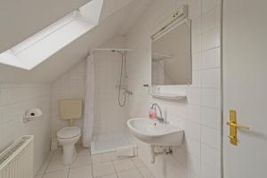 a white bathroom with a sink and a toilet at Panzió-Kemping Bekölce in Bekölce +39 photos