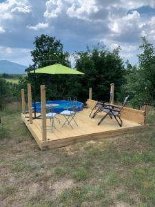 a wooden deck with a table and chairs and an umbrella at The Cabin On the Hill in Belogradchik