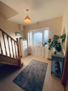 a hallway with a staircase and a door with a refrigerator at Atlantic Holiday Home in Milltown Malbay