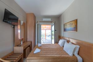 a hotel room with a bed and a television at Synodinos Studios in Lixouri