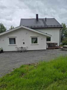 a white house with a picnic table in front of it at Utleiebolig Fannrem in Fannrem