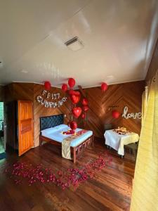 a room with a bed and two tables with red balloons at Villa Encanto in Bahía Solano