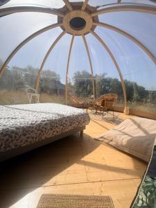a bed in a room with a large window at La bulle de Clemence in Montfermy