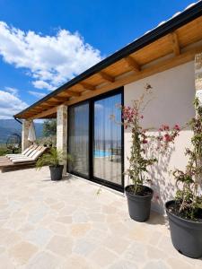 a patio with two potted plants on it at Terracotta Villa in Himare