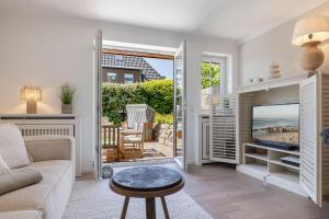 a living room with a view of the ocean at Strandliebe Sylt in Westerland