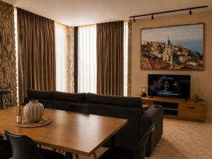 a living room with a table and a tv at Terracotta Villa in Himare