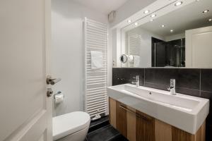 a bathroom with a sink and a toilet and a mirror at Strandliebe Sylt in Westerland +34 photos