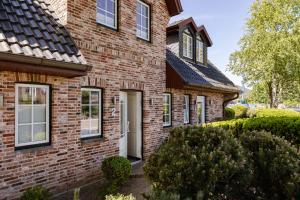 a brick house with a white door at Strandliebe Sylt in Westerland