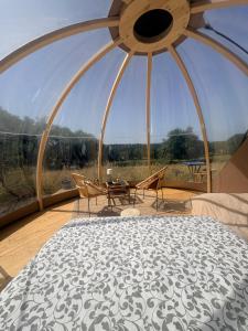 a room with a large window with a table and chairs at La bulle de Clemence in Montfermy