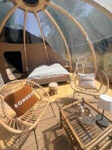 a room with a tent with chairs and tables at La bulle de Clemence in Montfermy +6 photos