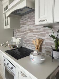 a kitchen with white cabinets and a counter top at Relax House Sardara in Sardara +29 photos